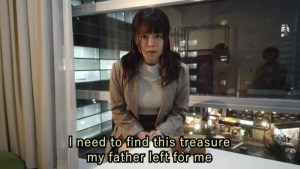 The main character in her apartment pleading, "I need to find this treasure my father left for me."