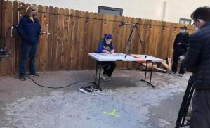 Wide angle shot shows Tammy solving the Guinness World Record puzzle with 3 witnesses and two cameras.