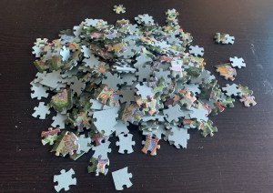 A pile of jigsaw puzzle pieces almost all of them have them same cuts.