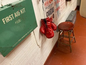 First aid kit, boxing gloves, and a stool in a boxing club.