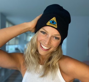 Woman wearing a black beanie with the RECON logo.