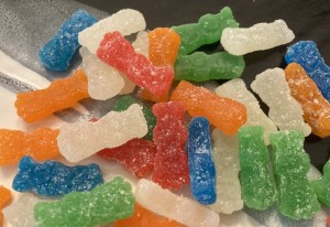 An assortment of traditional Sour Patch Kids with white mystery flavor gummies mixed in.