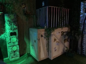 A dinosaur cage in a jungle setting.