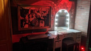 A well-lit makeup mirror over a desk backstage at a theatre.