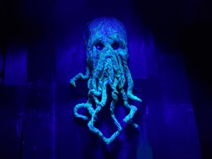 A sculpted head of Cthulhu dramatically lit.