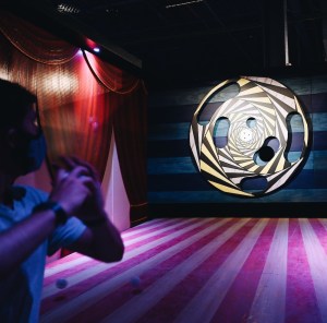 A player throwing a ball at an elaborate rotating target.