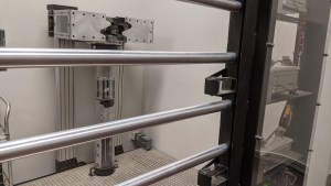 A diamond stored in an elaborate metal contraption, behind steel bars.