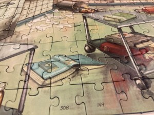 Closeup of a portion of the assembled puzzle, the lab is a mess.