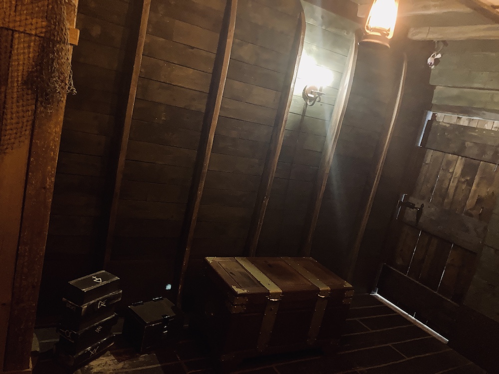 The interior of an old ship. There are a number of locked chests, one is especially large.