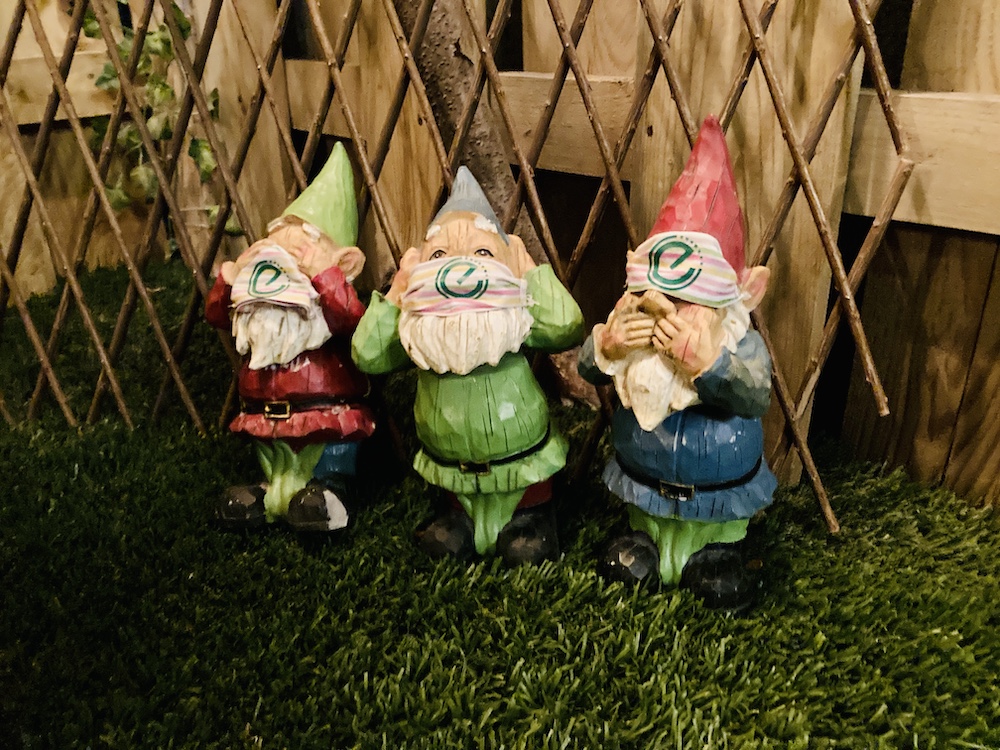 Closeup of 3 see no evil, speak no evil, hear no evil garden gnomes .