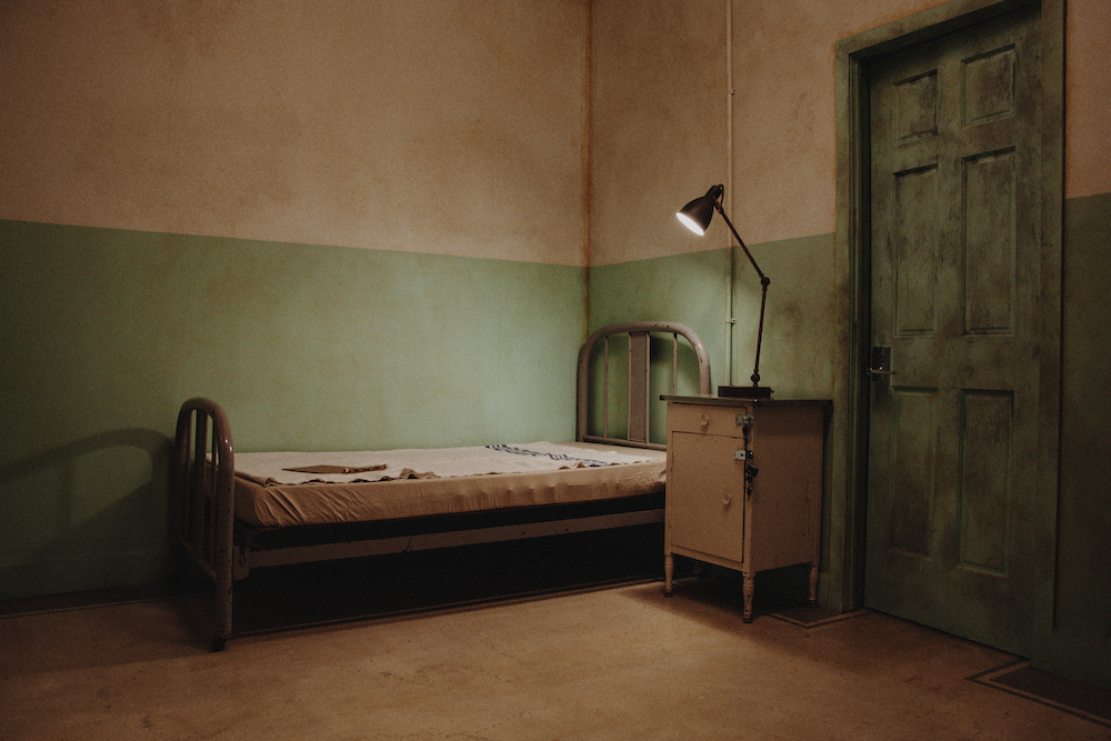 An hold hospital bed in a dingy hospital room.