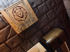 The Lionheart house crest features a red lion on a blue shield, it's mounted to a stone wall above a locked chest.