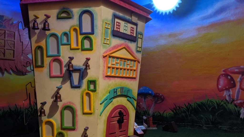 An oddly shaped house with many bells and colorful windows, it's labeled, "Hatter."