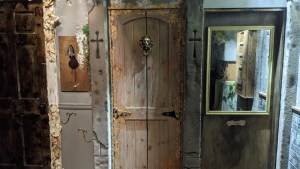 A wooden door with a lion's head knocker in an old building.