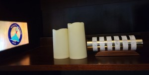 A projection of the REPOD logo beside some candles and a cryptex.