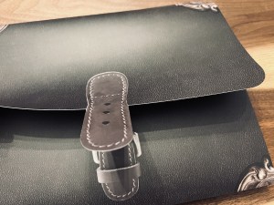 Opening a puzzle portfolio. It looks like a black leather case.