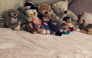 A bed covered in assorted plushies.