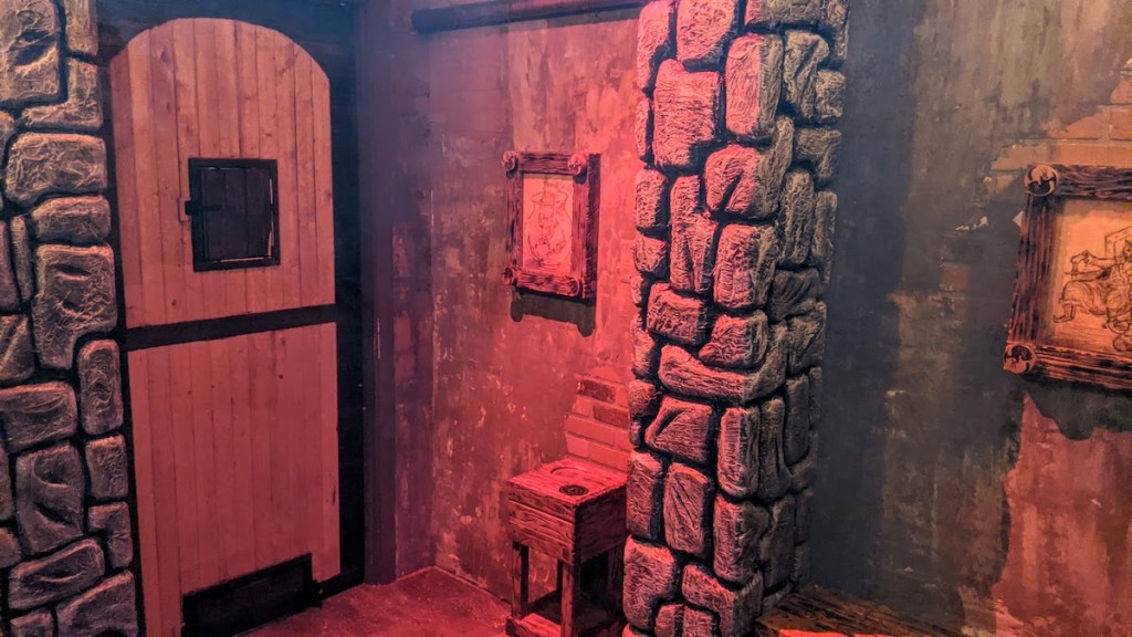 Castle interior with a large wooden door and stone walls.