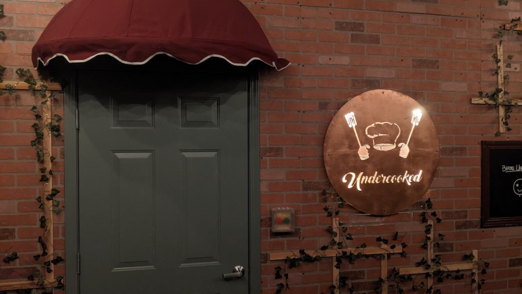 Exterior of a restaurant with a sign that has a chef's hat labeled, "Undercooked."