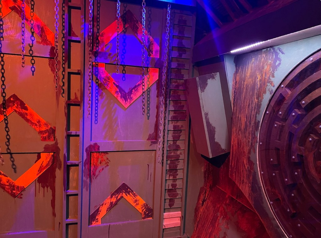 Metal devices and chains, dramatically lit.