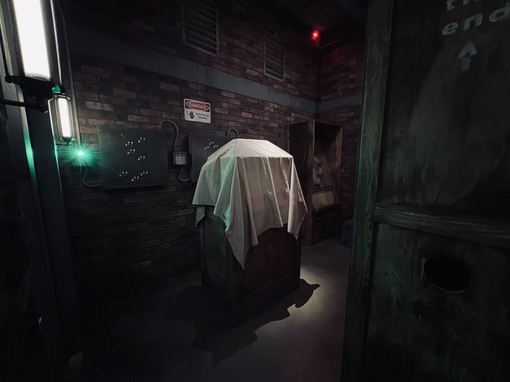 A box covered in a white sheet in a warehouse.