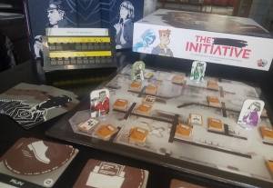 The Initiative game box, mission console with an unrevealed code, resource deck, and game pieces set up on the board.