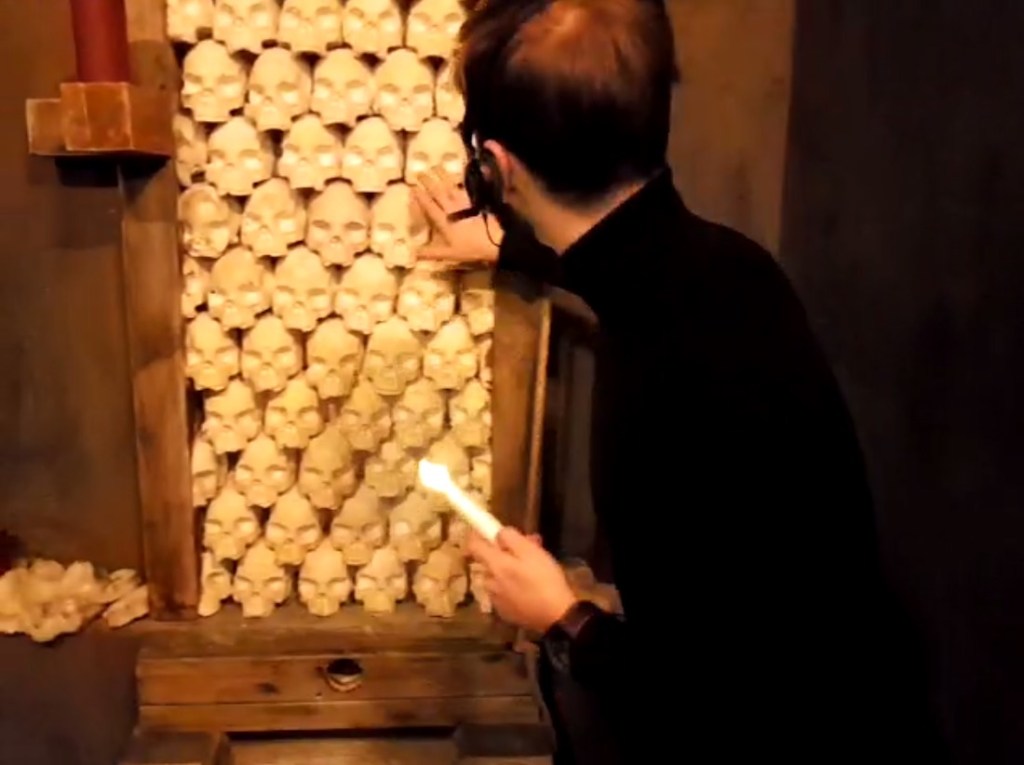 Avatar approaching a wall of skulls.