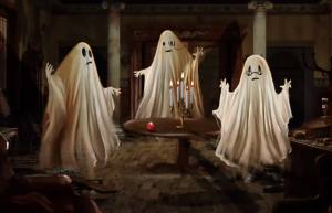 Three cute sheet ghosts around a table.