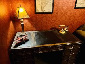 Closeup of a desk with a biplane and a telephone.