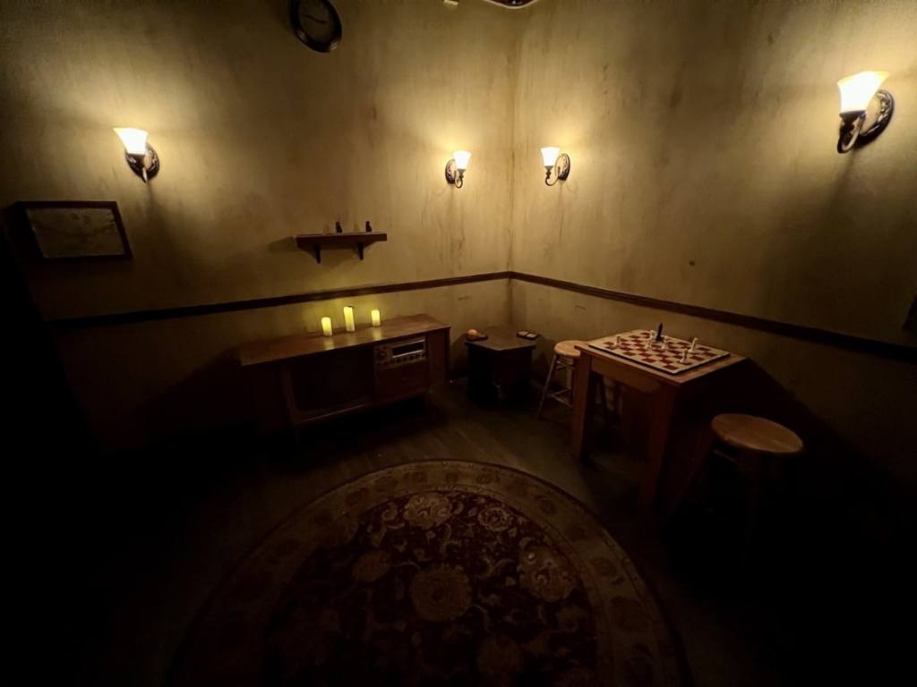 A dim room with chess sets and a tv.