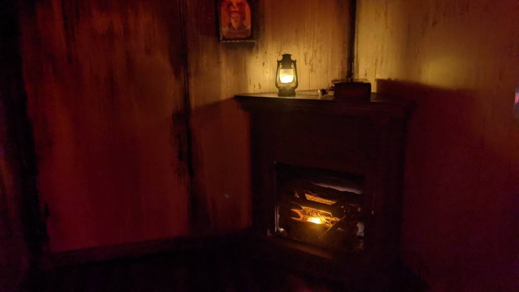 A fireplace and lantern in a dim corner.