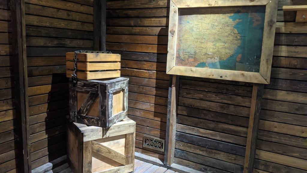 A stack of wooden crates beside a map inside of an attic.
