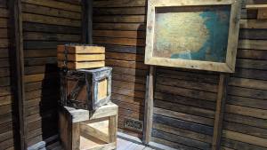 A stack of wooden crates beside a map inside of an attic.