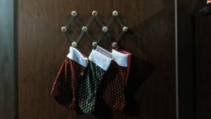 3 stockings hanging on a wall.