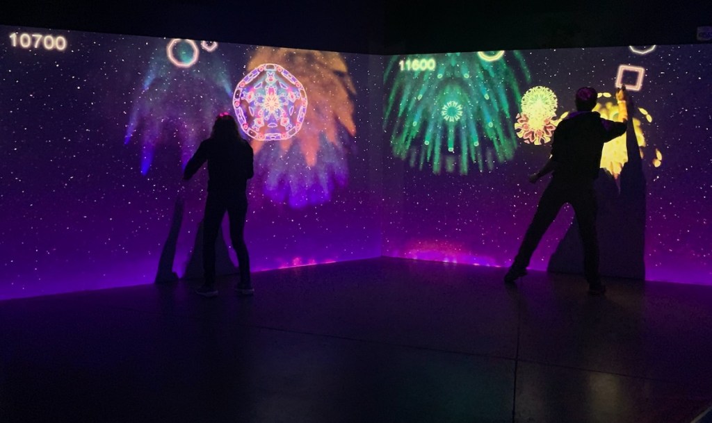 Two people playing a projected video game.