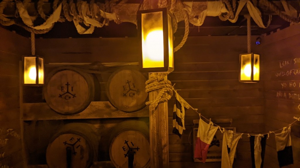 Barrels, rope, and flags in a ship's hold.