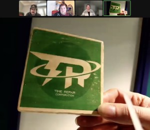 Zoom view of the game, a hand holds up a card labeled, "Time Repair Corporation."