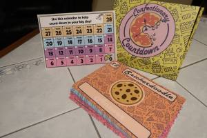 Confectionary Countdown box beside a calendar and a stack of cards.