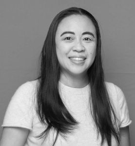 black and white photo of an asian woman with long straight hair in a white shirt.