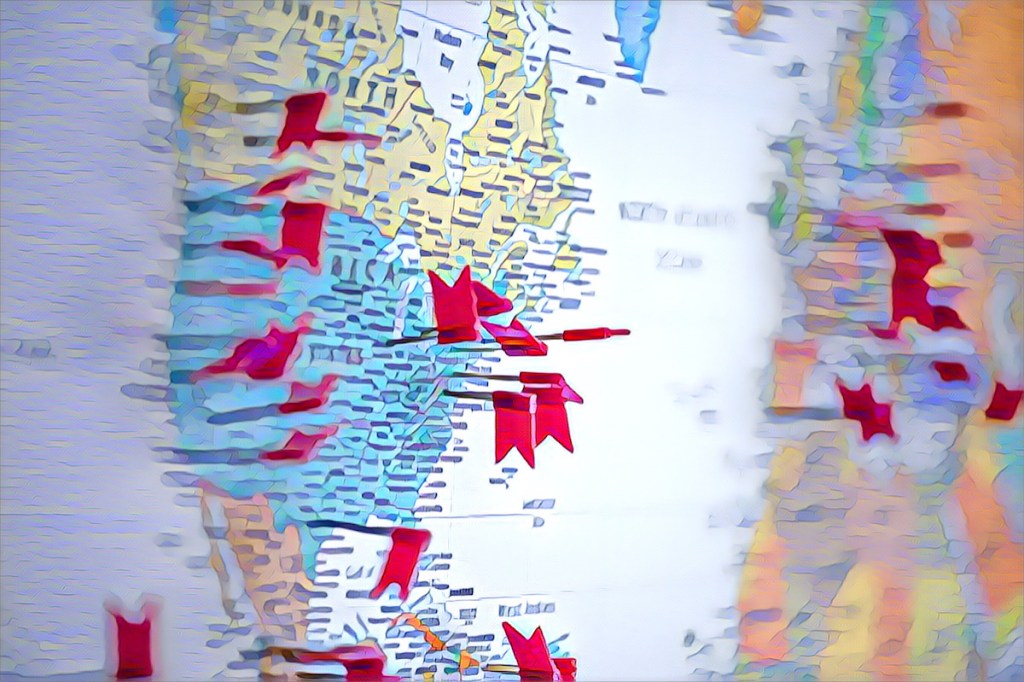 World map with flag pushpins, view is focused on North America.