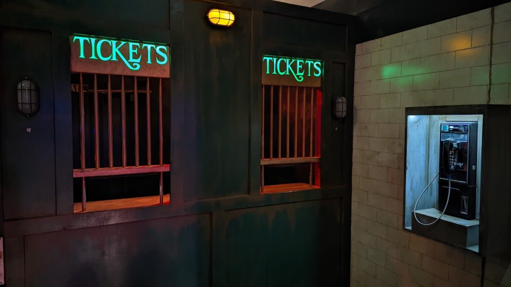 A ticket counter beside a payphone.