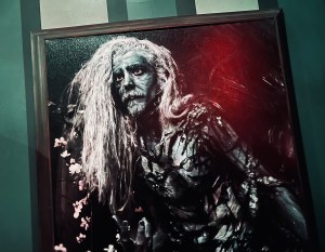 Closeup of a black and white painting of a cursed old man.