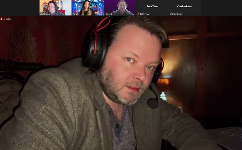 The game host looking into the camera intensely. He's wearing a headset with a microphone.