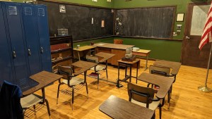 An old classroom, with desks lined up and tall blue lockers.