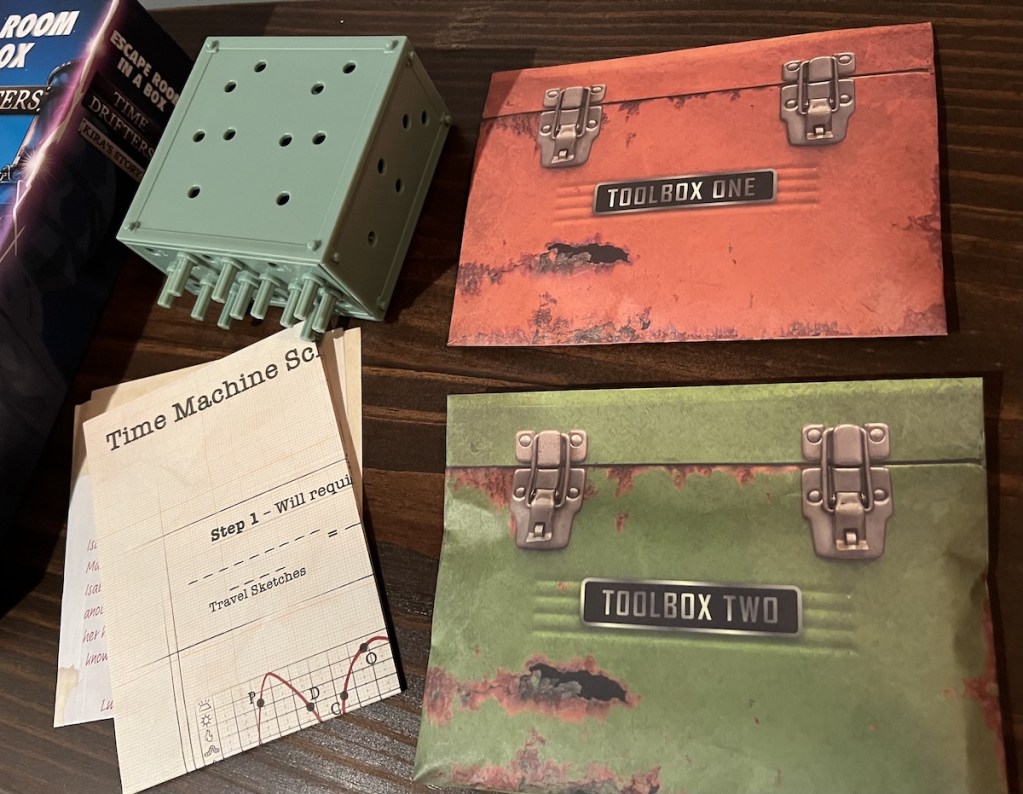 Two toolbox envelops beside a blue gearbox and some paper.