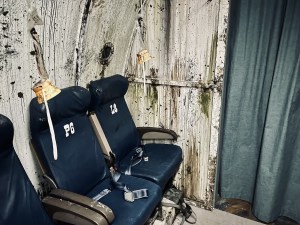 Airplane seats and a cabin curtain in the wreckage of a plane.