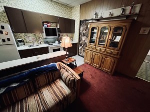 A living room and kitchen, everything is very brown and 80s.