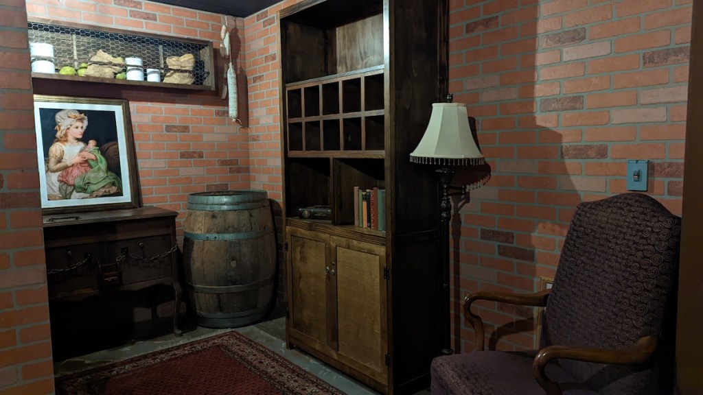 Brick walled room filled with furniture, and a barrel.
