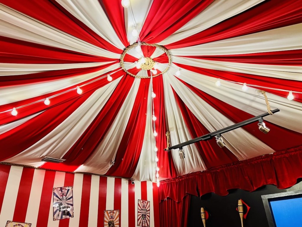 The ceiling of a a big top tenet made from red and white fabric.