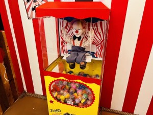 A vending machine with a animatronic clown on a swing. The machine is labeled, "Ziggy the Clown."